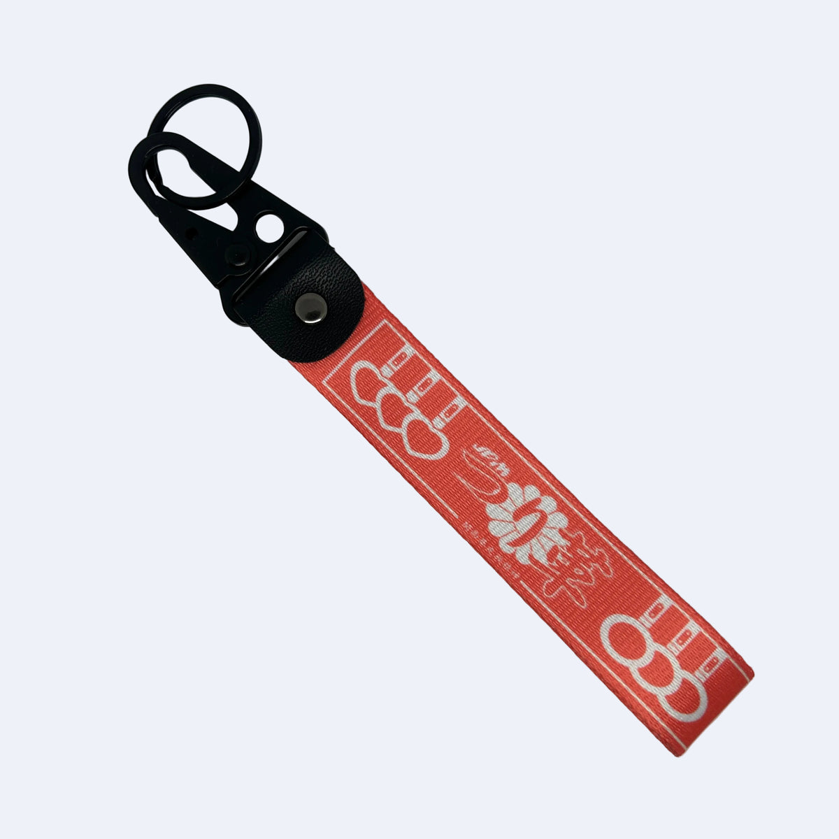 A red fabric keychain strap with a black plastic key ring and metal snap, featuring white printed graphics and text