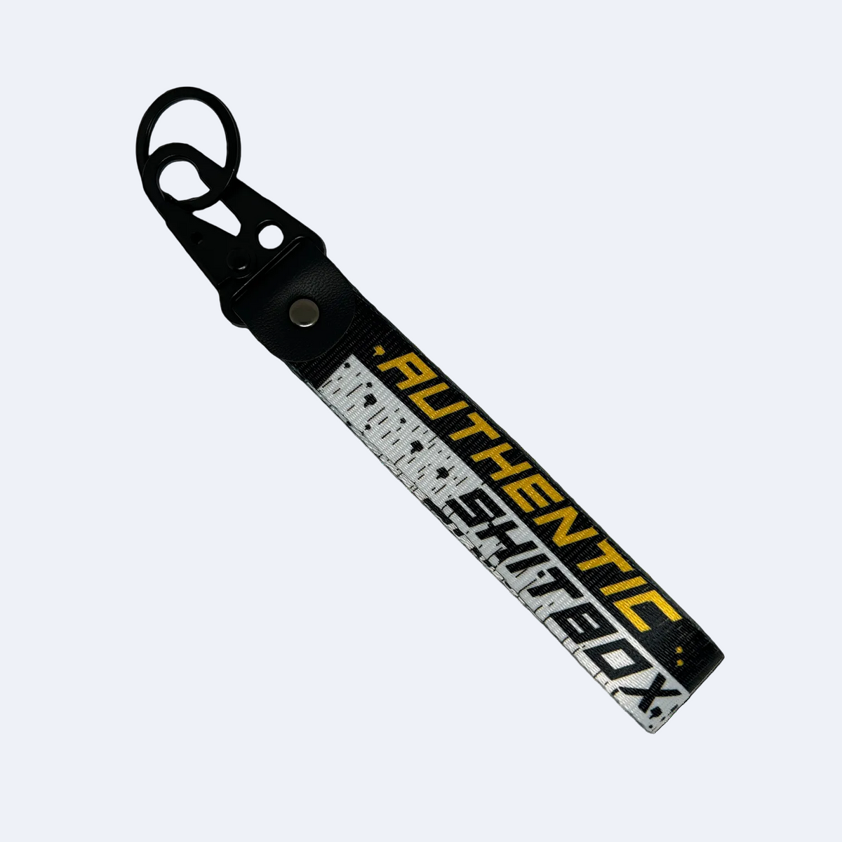 Back side of a black, white and yellow keychain with gritty design reading "Authentic Sh*tbox" – Motorev automotive keychain accessory