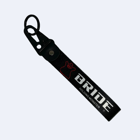 Black key tag with BRIDE HOLDING MONSTER branding in white print – Motorev embroidered car keychain