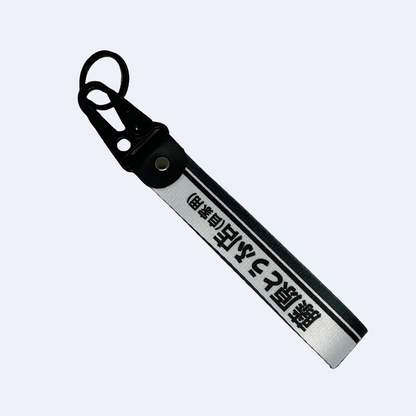 White keychain with a black line accent feauring Japanese text reading "Fujiwara Tofu Shop" – Motorev JDM car accessory