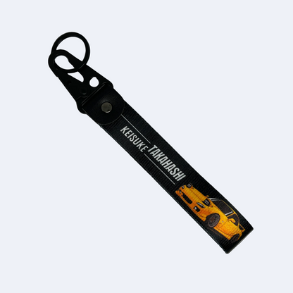 Motorev Initial D Keisuke Takahashi car key tag, a zinc alloy and nylon JDM keyring featuring the iconic Akagi RedSuns Mazda RX-7 driver, scratch resistant and built for JDM and anime car culture enthusiasts UK