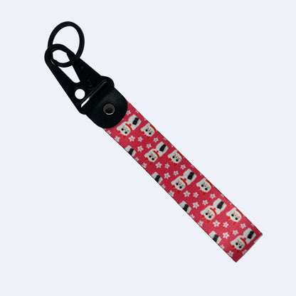 A fabric wristlet strap with a black plastic carabiner clip, featuring a pink patterned strap with white Sakura Maneki-Neko