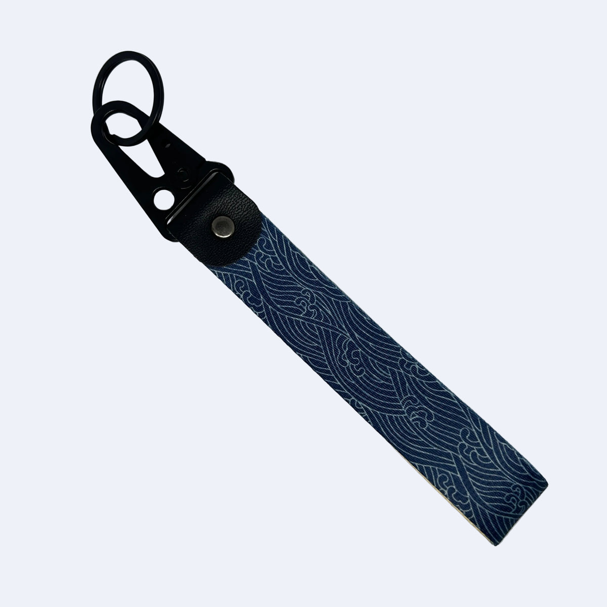 A blue and white wave-patterned leather keychain strap with a black metal carabiner clip, shown on a plain light gray background.
